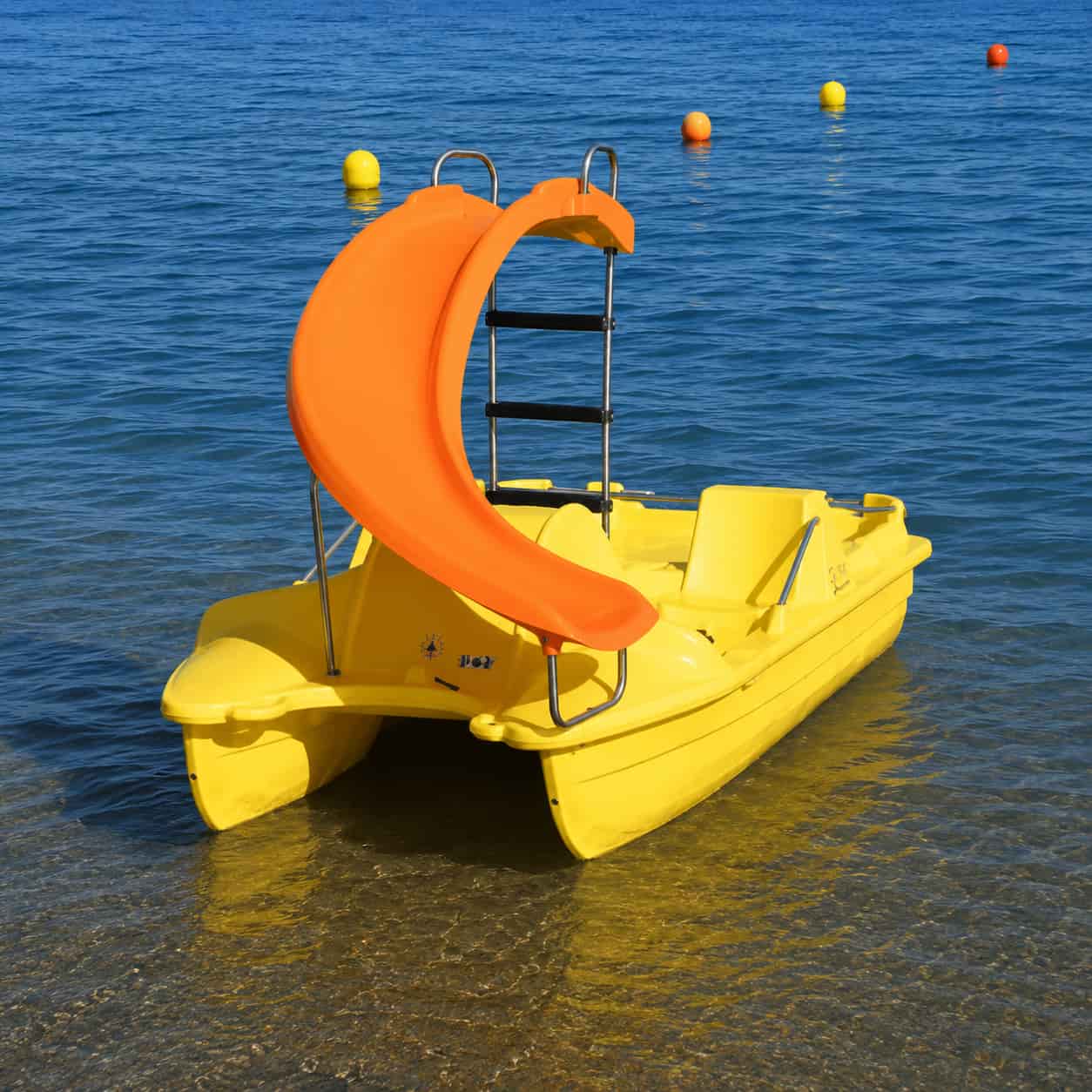 Pédalo P4P jaune avec toboggan orange au bord de la mer