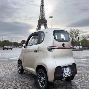 Voiture sans permis Li-bellule grise à Paris devant la Tour Eiffel